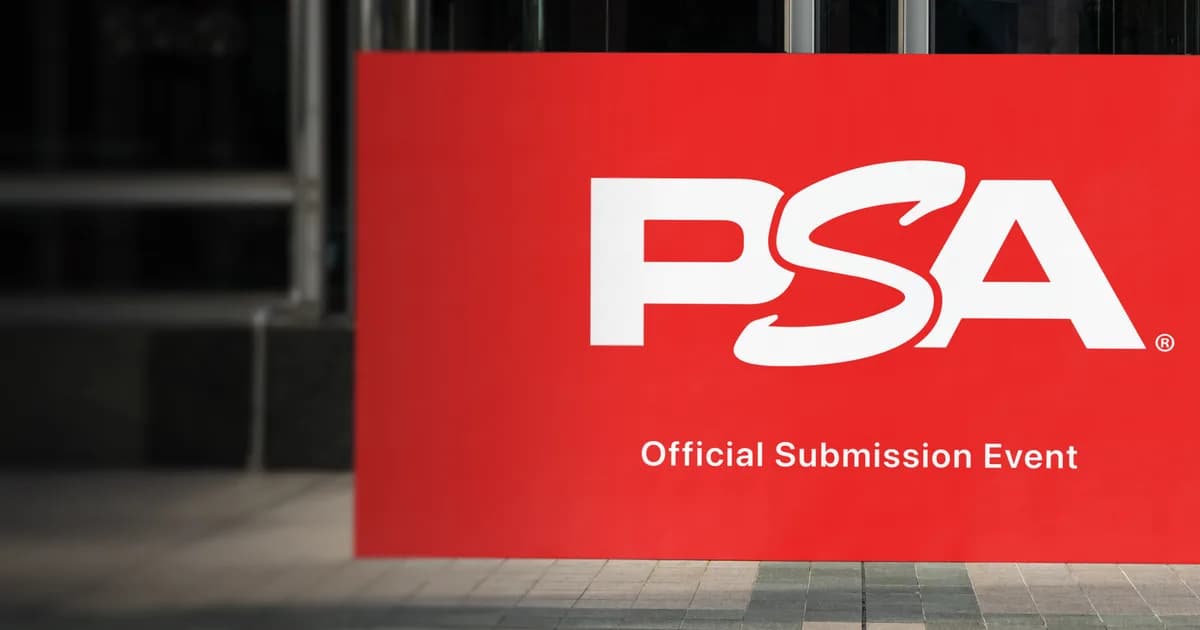 Red PSA sign reading Official Submission Event standing outside a glass building entrance on a paved walkway