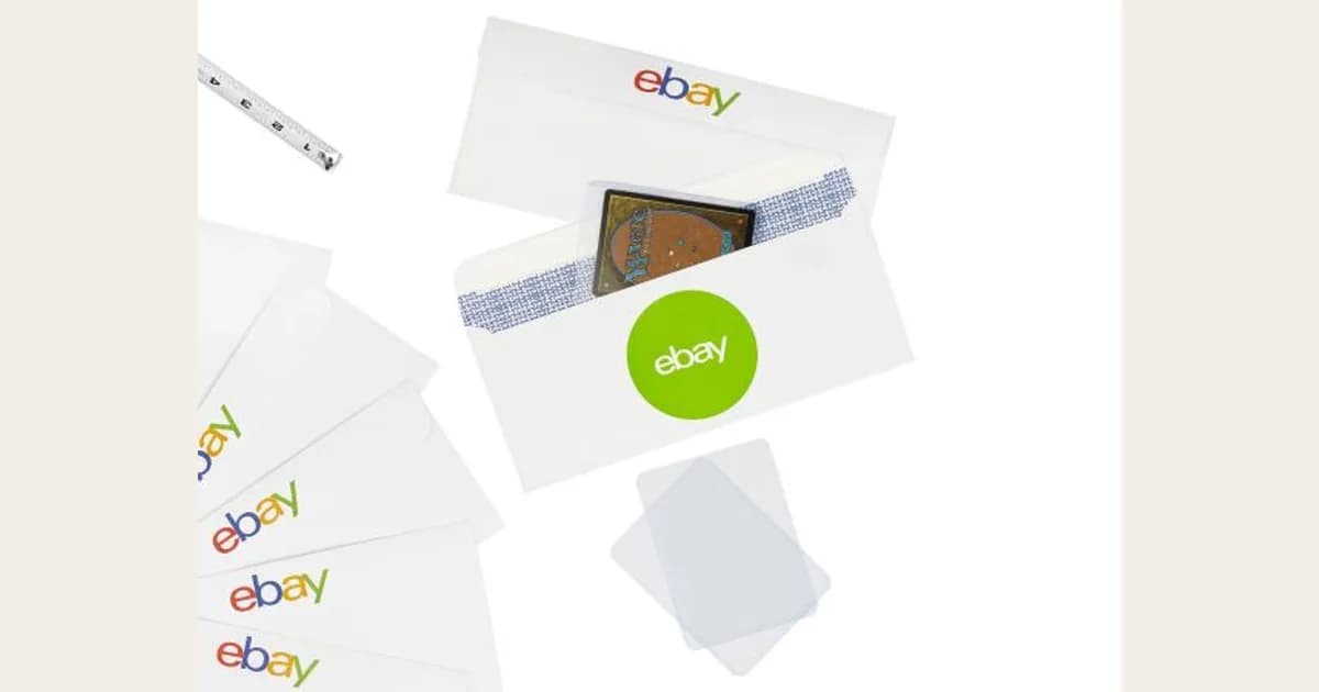 A trading card taped inside a white eBay standard envelope with a green eBay sticker, a toploader beside it and a tape measure